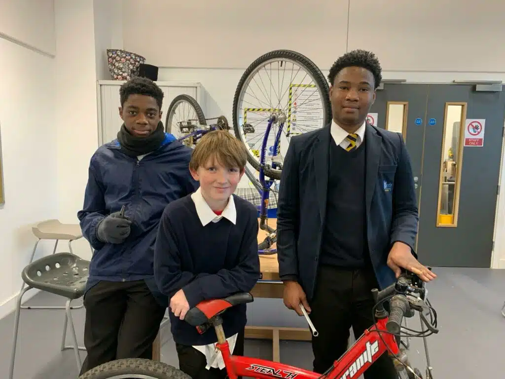 Martin Nnadiwuagha, Blake Holders and Jakim Emmanuel with one of the bikes they are repairing