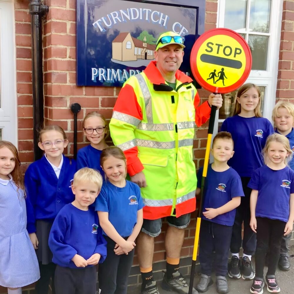 Pete the lollipop man with children outside Turnditch Primary School